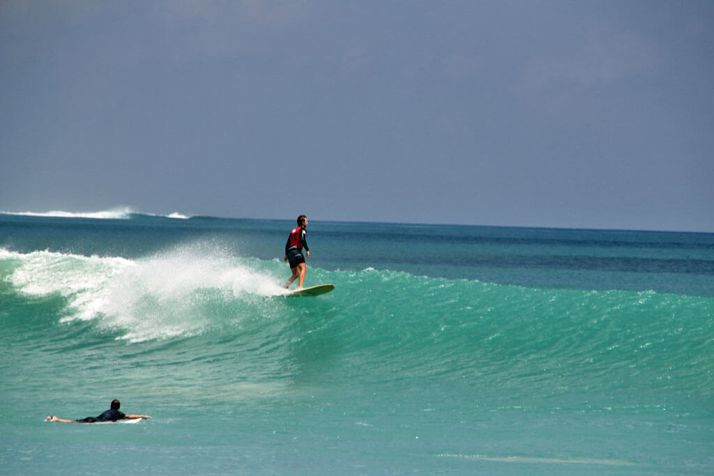 Ein Surfer surft auf einer hohen Welle in Uluwatu.