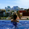 Frau im Hotelpool mit Blick auf die Stadt Phnom Penh