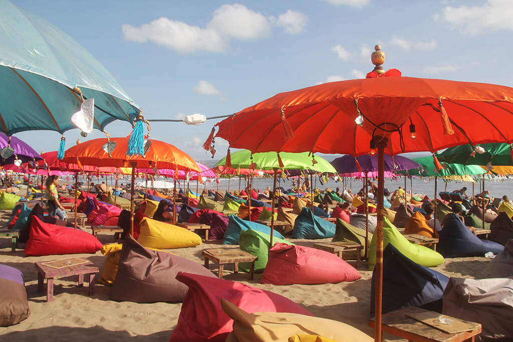 Strandbar mit bunten Schirmen und Sitzsäcken am Strand von Bali.