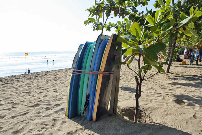 Surfbretter stehen zusammengebunden an einem Strand