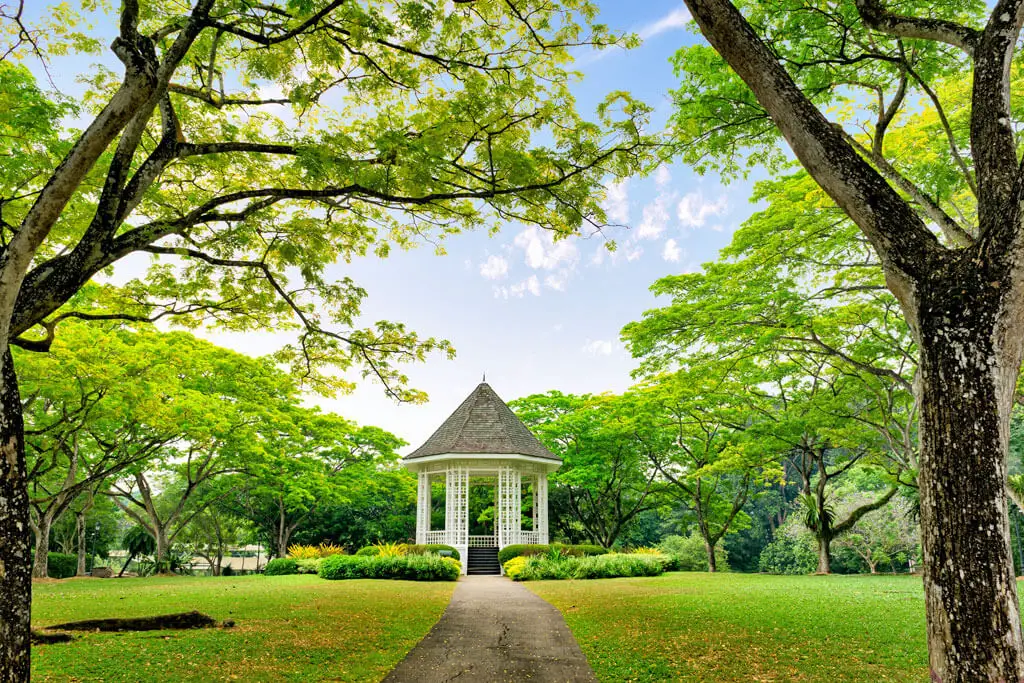 Kleine Pagode umgeben von Rasenfläche und Bäumen im Singapore Botantic Garden