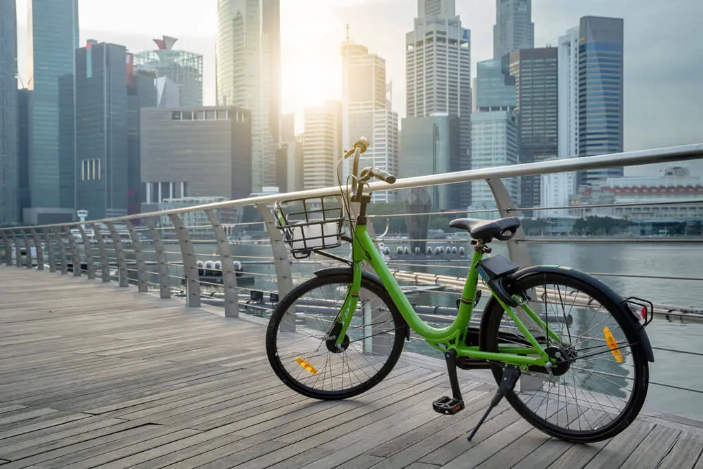 Grünes Fahrrad in Singapur mit Hochhäusern im Hintergrund