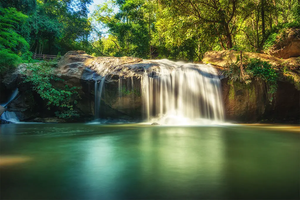 Mae-Sa-Wasserfall umgeben von grünen Bäumen