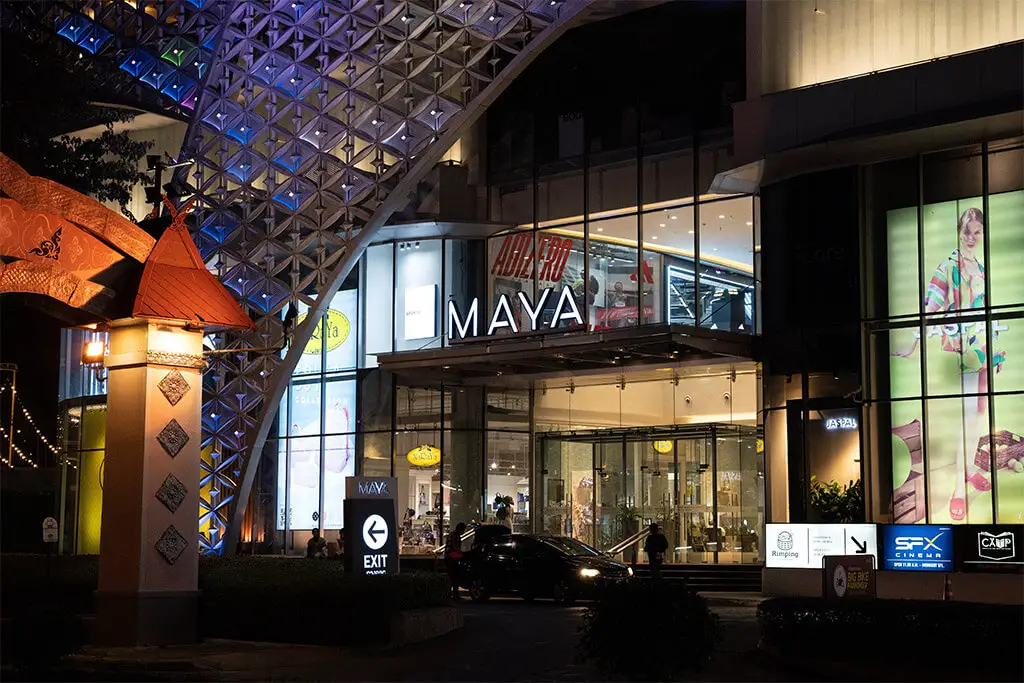 Beleuchteter Eingang mit Schild zum MAYA Lifestyle Shopping Centre in der Nacht
