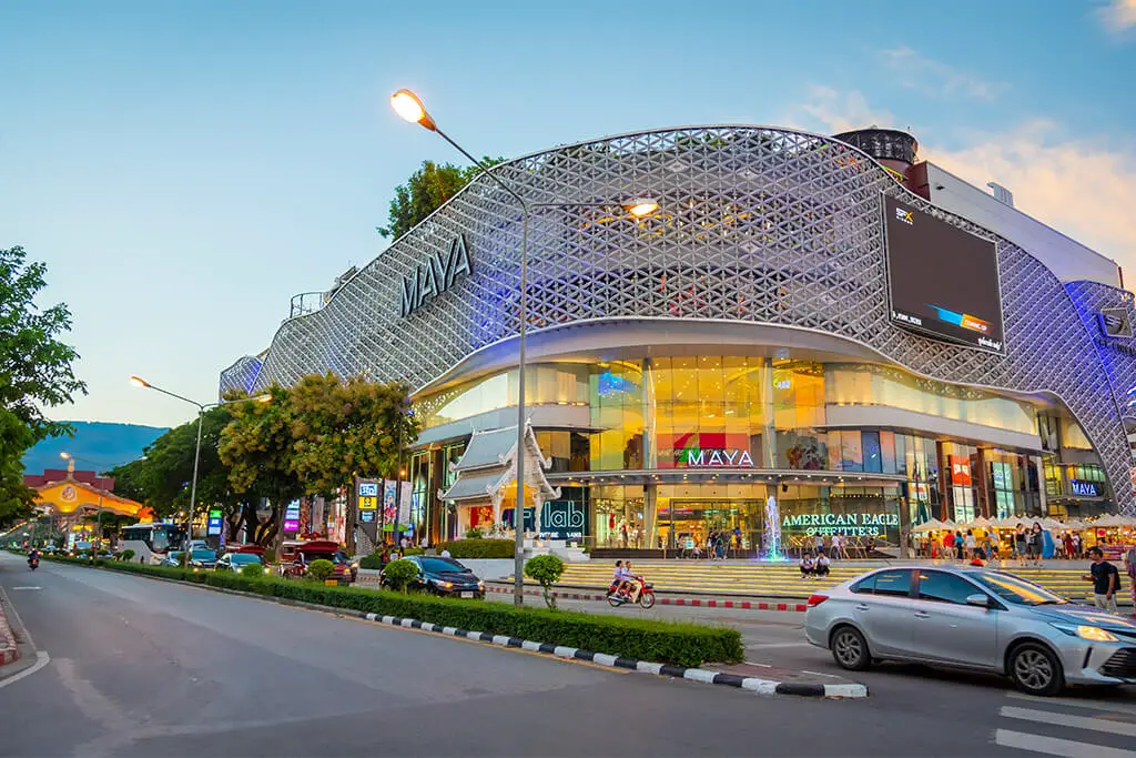 Fassade des Maya Lifestyle Shopping Centre in Chiang Mai mit befahrener Straße und Autos im Vordergrund