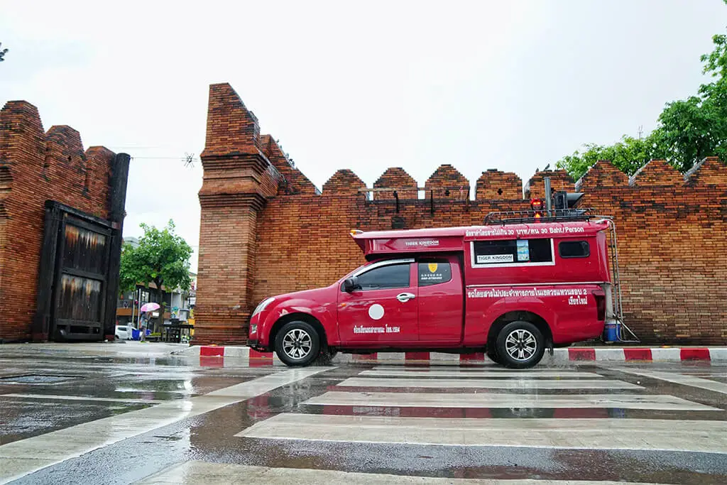 Rotes Sammeltaxi for vor dem Tha Phae Gate und der alten Stadtmauer in Chiang Mai