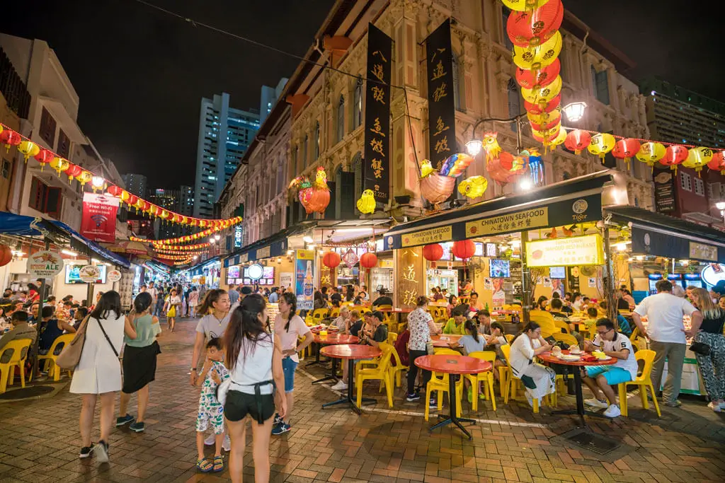 Nächtliches Chinatown in Singapur mit vielen Tischen vor den Restaurants und Gästen