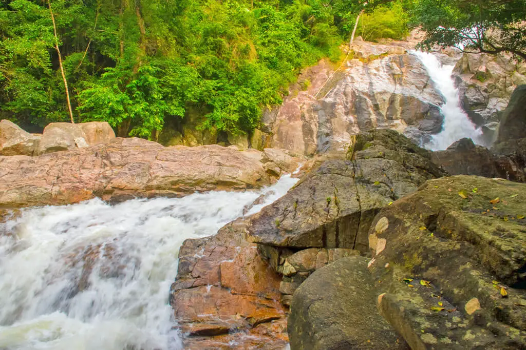 Ein rauschender Wasserfall schlängelt sich durch imposante Felsen inmitten des Dschungels