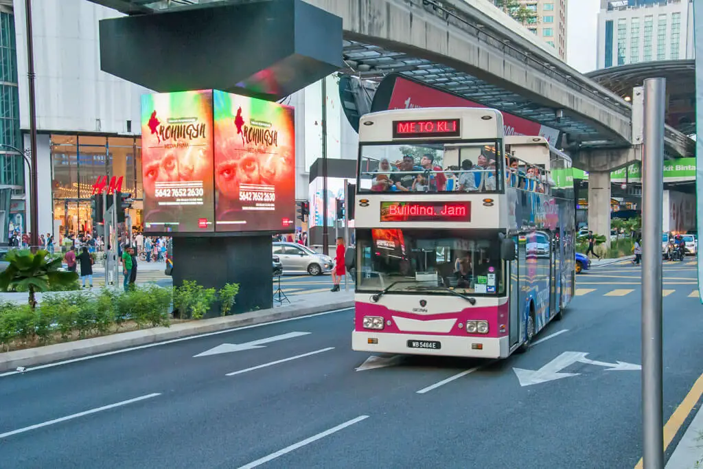 Ein Doppeldecker-Bus mit offenem Dach fährt Touristen durch die Stadt