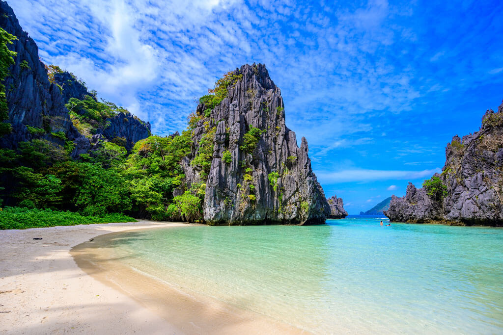 Flaches türkisblaues Meer und heller Sandstrand umrandet von schroffen Felsformationen, Hidden Beach, El Nido, Philippinen