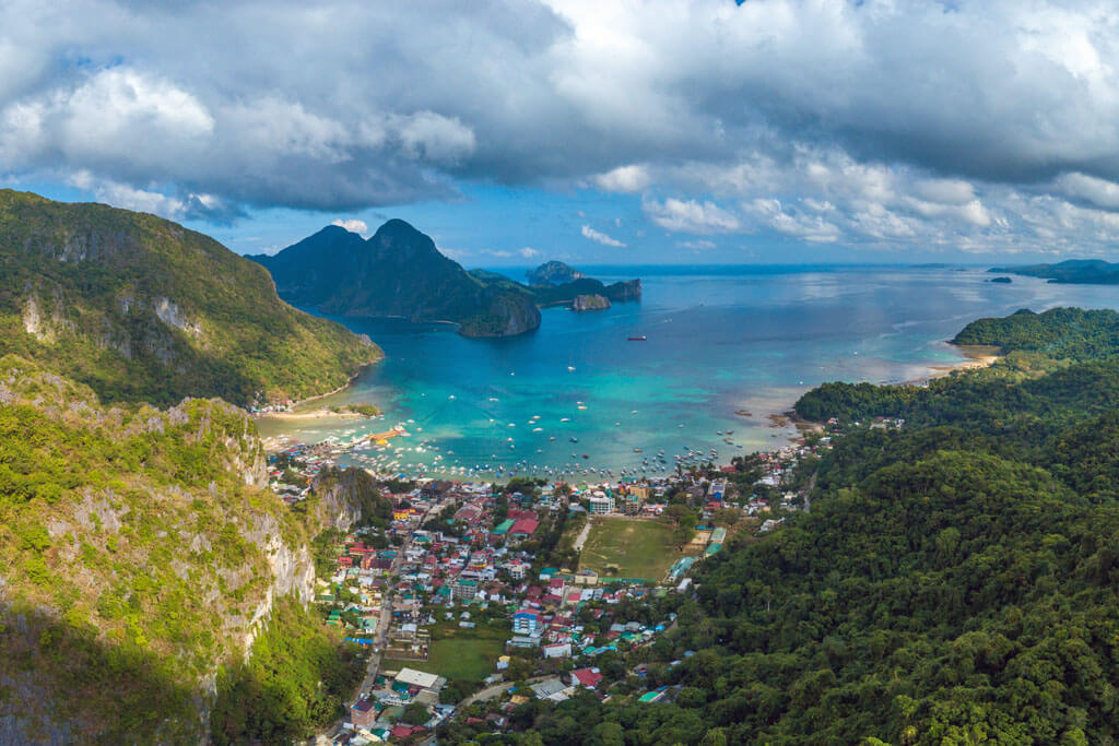 Häuser der kleinen Stadt El Nido auf den Philippinen, umgeben von Felsen und türkisblauem Meer