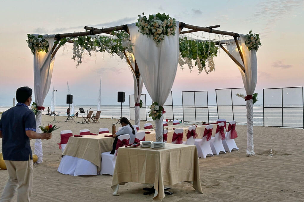 Hochzeitsdekoration mit geschmückten Tischen und Stühlen zum Sonnenuntergang am Strand