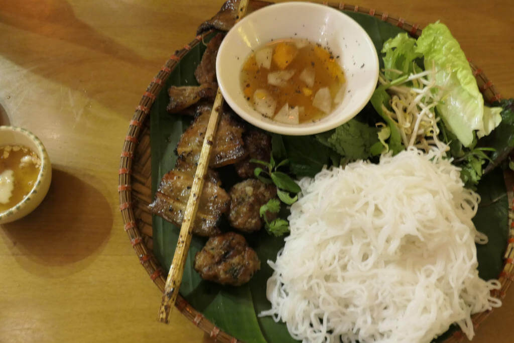 Bun Cha, (c) Andrea Markand Das Bild zeigt einen Teller mit dem nordvietnamesischen Gericht Bun Cha: Reisnudeln mit Fleisch, Kräutern und Brühe