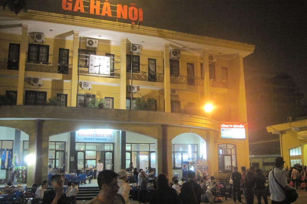 Der Bahnhof von Hanoi, (c) Mark Markand Fassade des belebten Bahnhofs von Hanoi am Abend