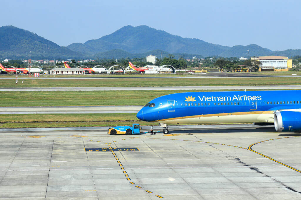 Noi Bai Airp0rt, Hanoi. Auf dem Rollfeld ist der Vorderteil einer blauen Vietnam-Airlines-Maschine zu sehen.