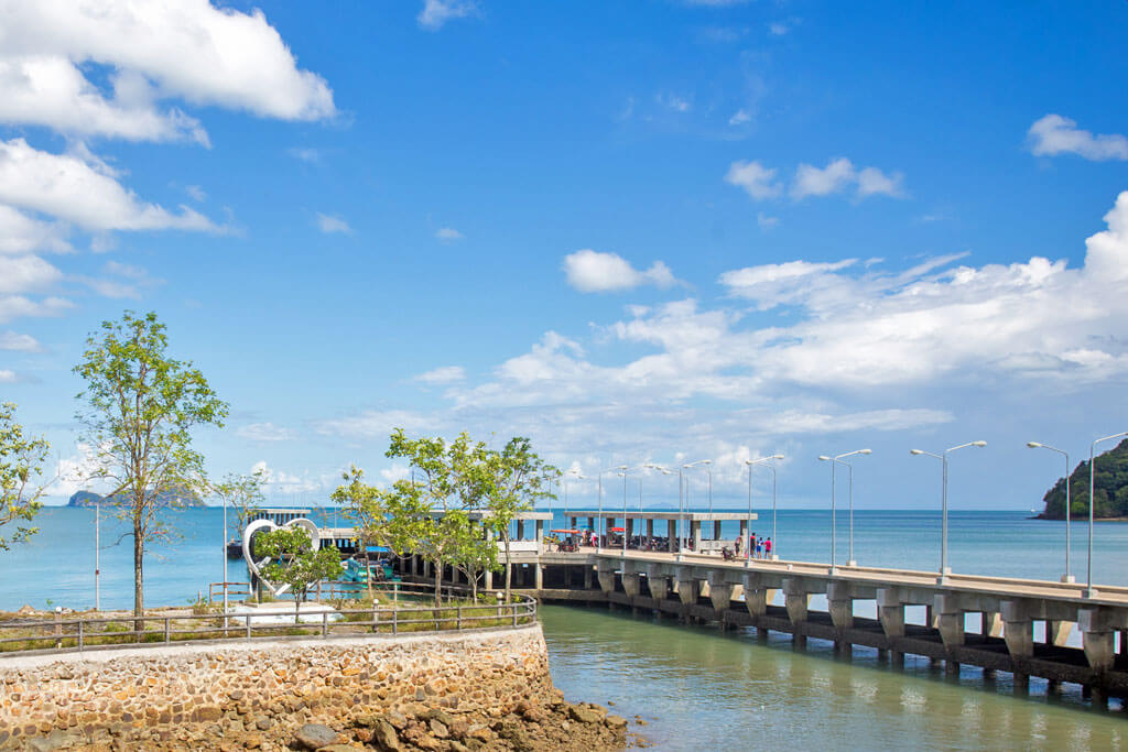Ein Bootsanleger aus Beton mit Bäumen und Straßenlaternen