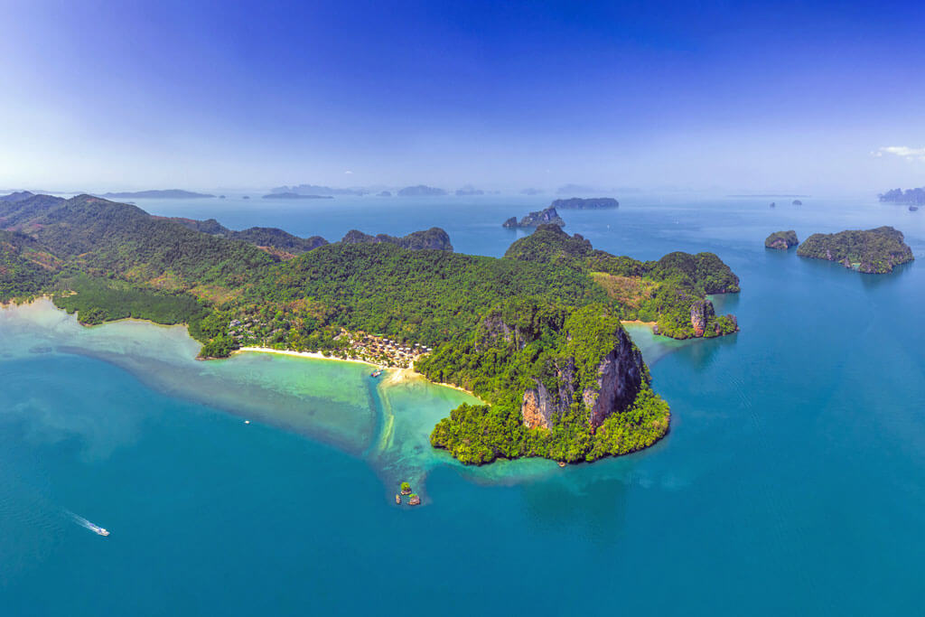 Luftaufnahme auf die Insel Koh Yao Noi mit einem Strand und hohen Kalksteinfelsen