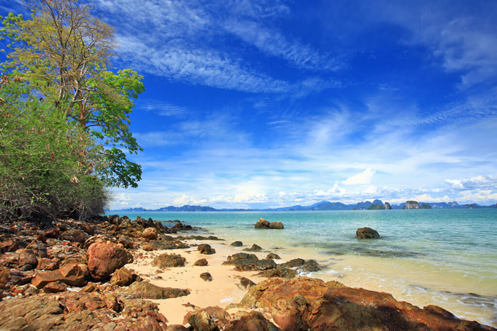 Ein Strand mit vielen Steinen unter blauem Himmel