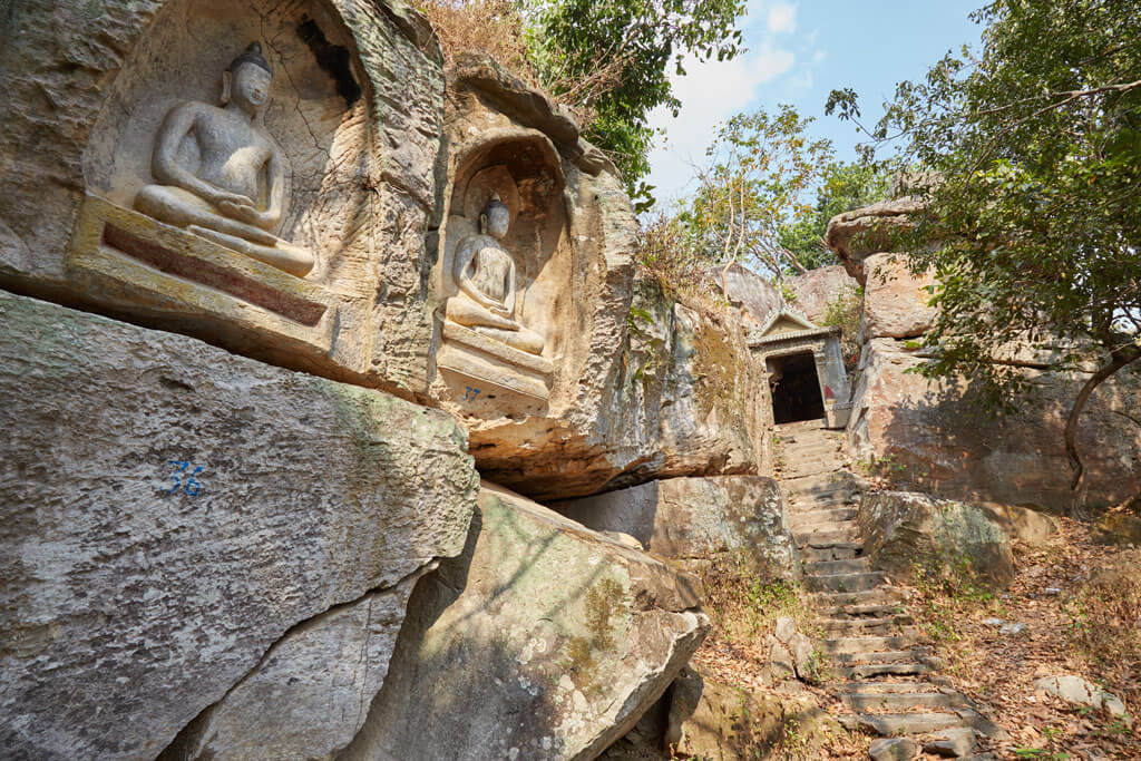 Höhlentempel mit Buddha-Figuren und einer Treppe, die zum Eingang des Tempels führt