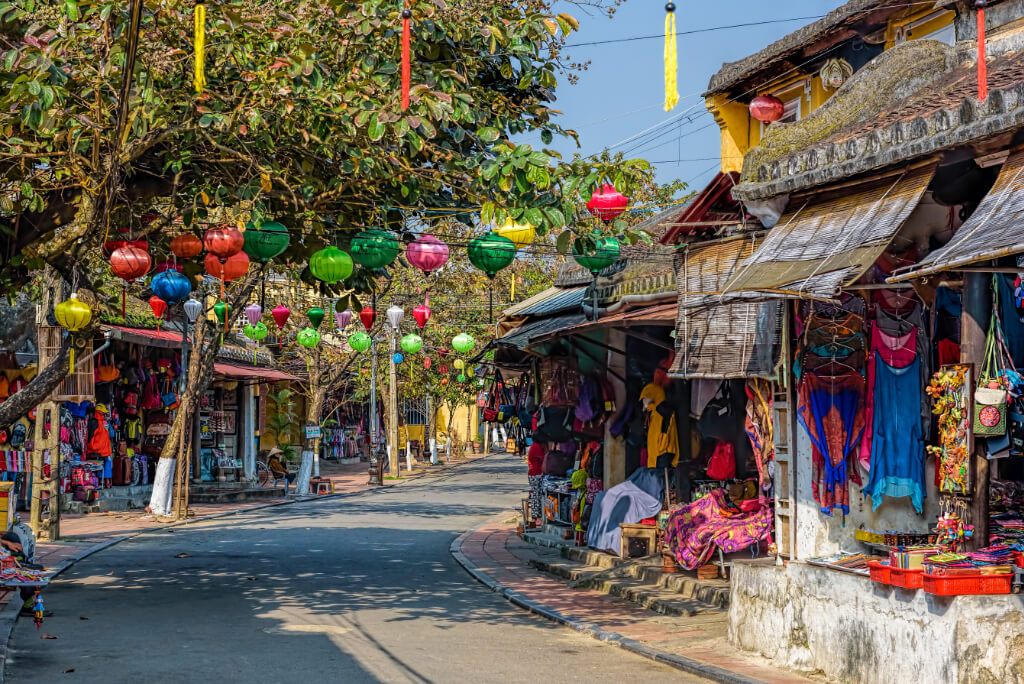 Leere, von Geschäften gesäumte und mit Lampions dekorierte Straße in der Altstadt von Hoi An