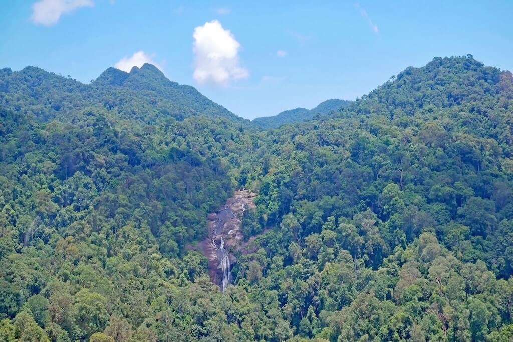 Blick auf den Telaga Tujuh Waterfall auf Langkawi, umgeben von grünem, dichtem Dschungel.