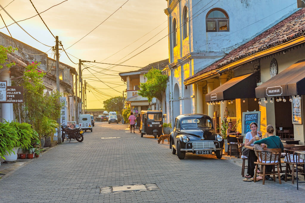 Eine Altstadt bei Sonnenuntergang mit historischen Gebäuden und Straßen-Restaurants