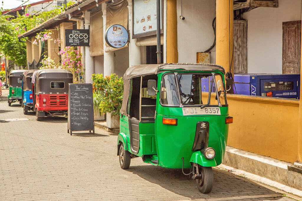 Ein grünes Tuk-Tuk steht in einer Straße in der Altstadt