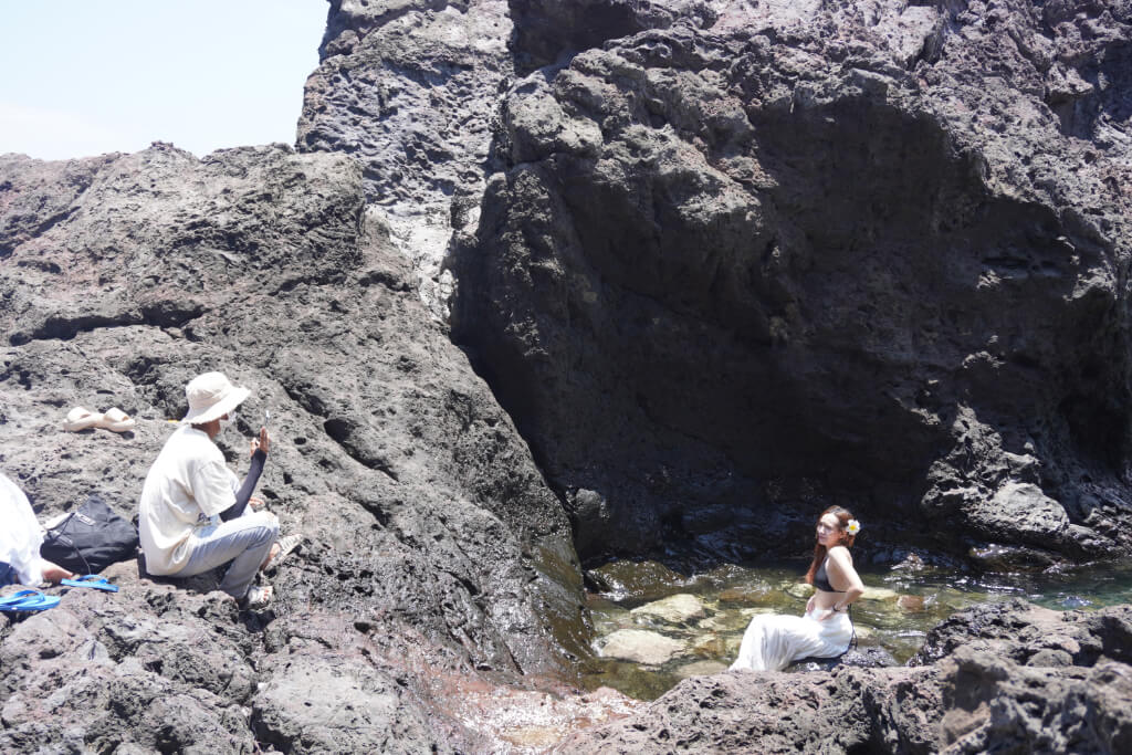 ein vietnamesisches Paar an einem felsigen Küstenabschnitt auf Phu Quy