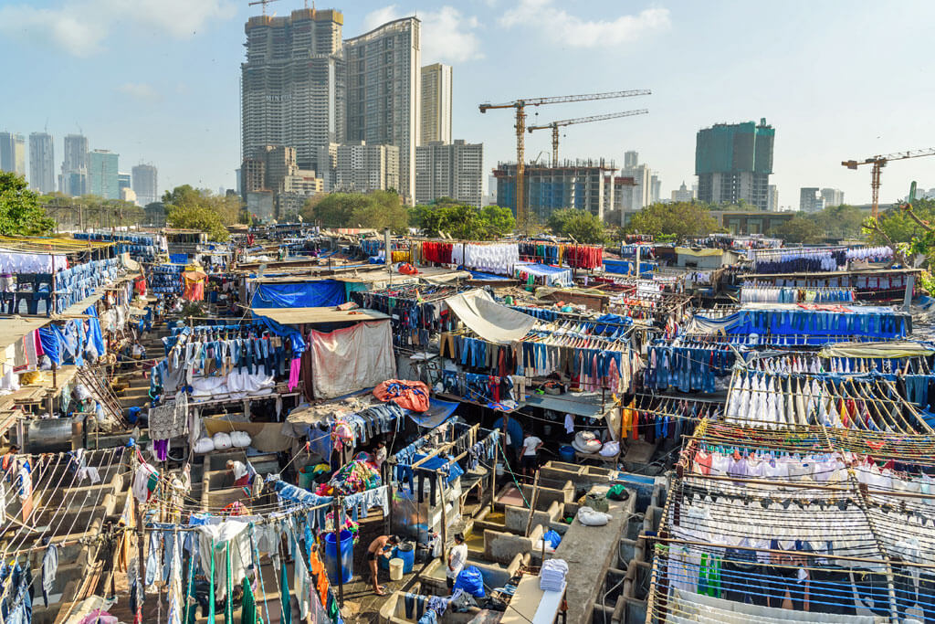 Eine riesige Freiluft-Wäscherei mit vielen Stoffen, im Hintergrund Hochhäuser