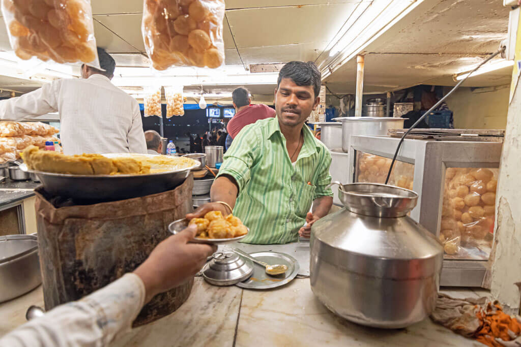 Ein Straßenhändler in Indien bereitet Chaat und Pani Puri zu