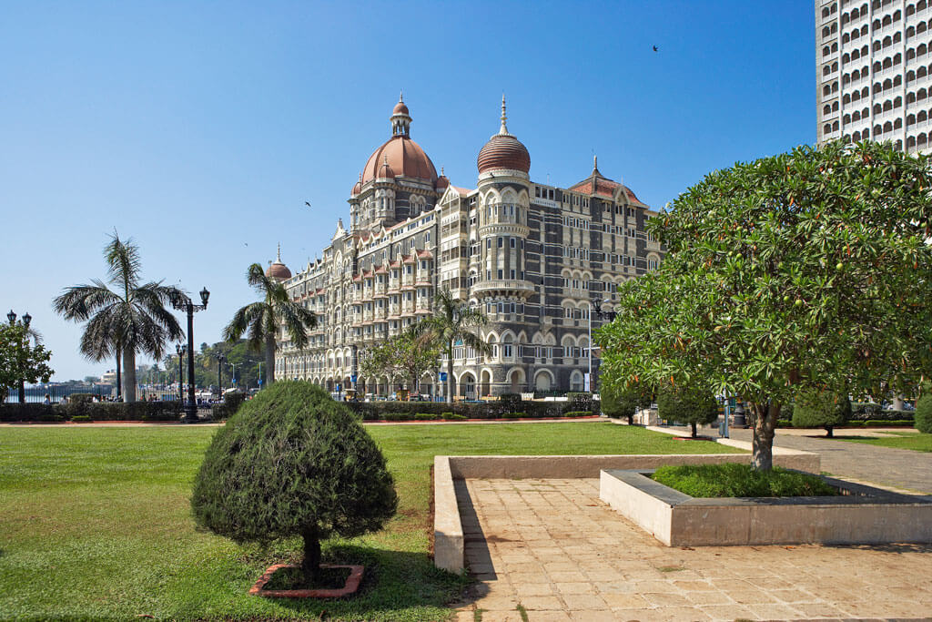 Das Kolonialgebäude des Taj Mahal Palace Hotel vor einem Park