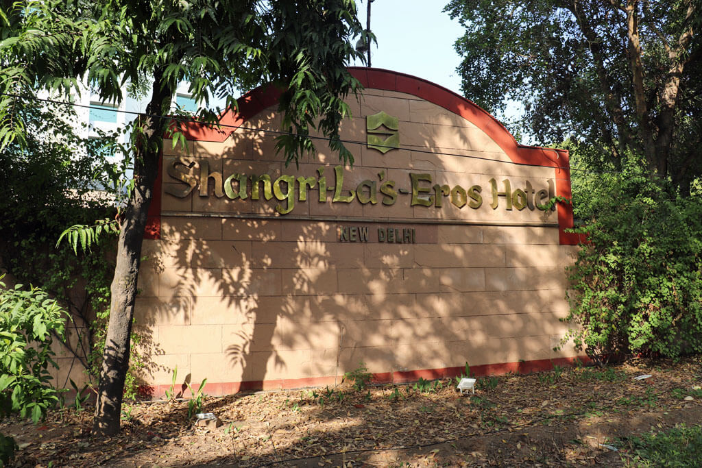 Schriftzug des Shangri La Eros Hotel in New-Delhi umgeben von Bäumen